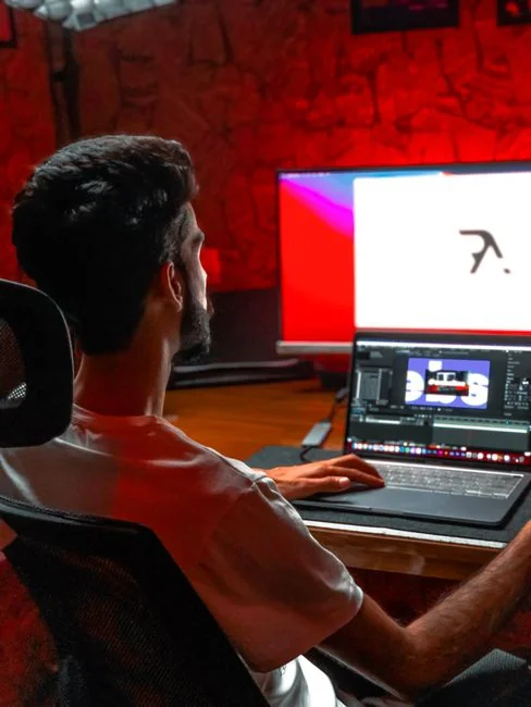 A modern workspace featuring dual computer monitors displaying web design projects, emphasizing technology and productivity.