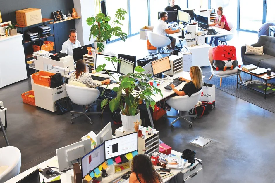 Une personne travaille sur un ordinateur portable avec une tablette graphique pour du design numérique dans un bureau à domicile.